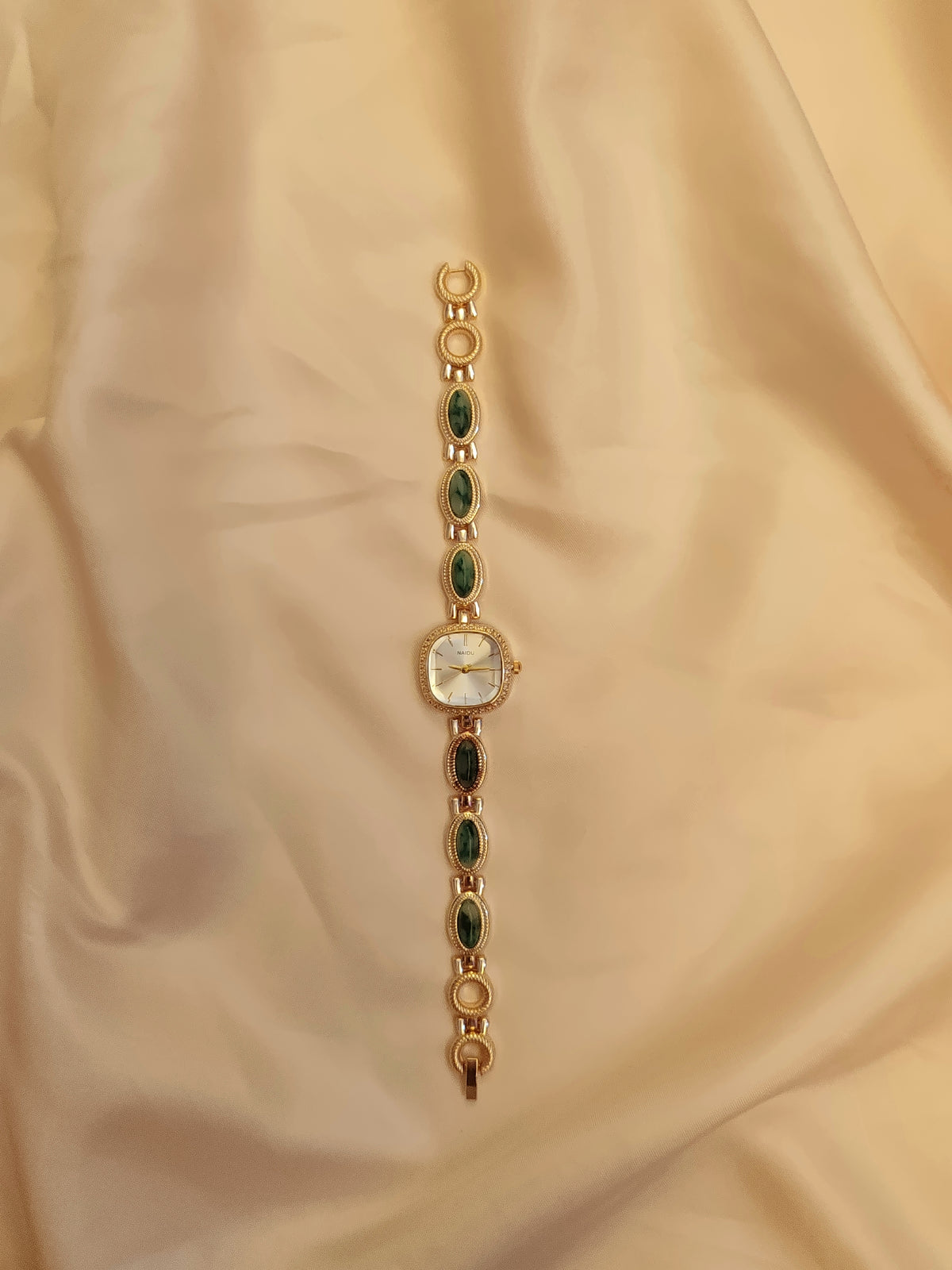 Emerald -  Goldene Schmuckuhr mit grün marmorierten Schmucksteinen