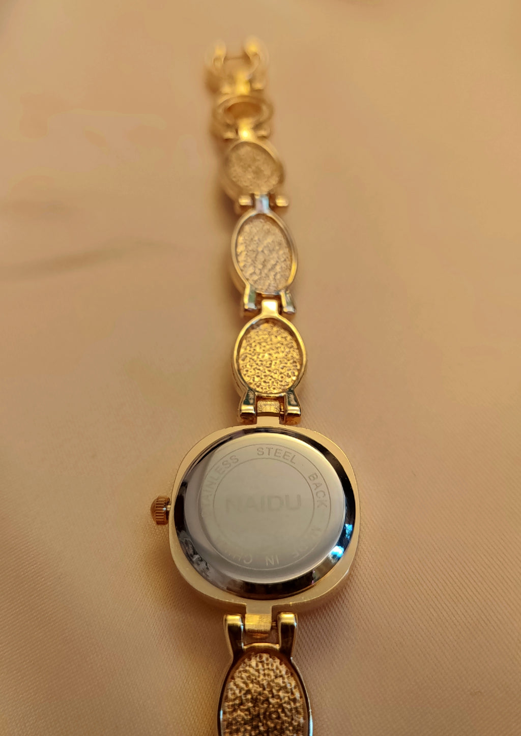 Emerald -  Goldene Schmuckuhr mit grün marmorierten Schmucksteinen