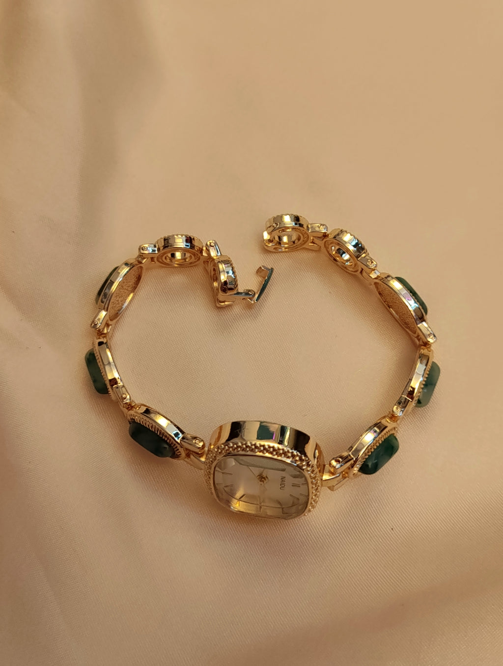 Emerald -  Goldene Schmuckuhr mit grün marmorierten Schmucksteinen