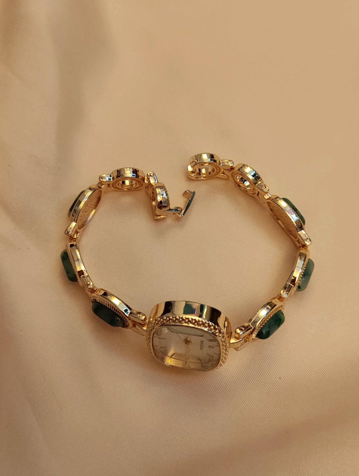 Emerald -  Goldene Schmuckuhr mit grün marmorierten Schmucksteinen