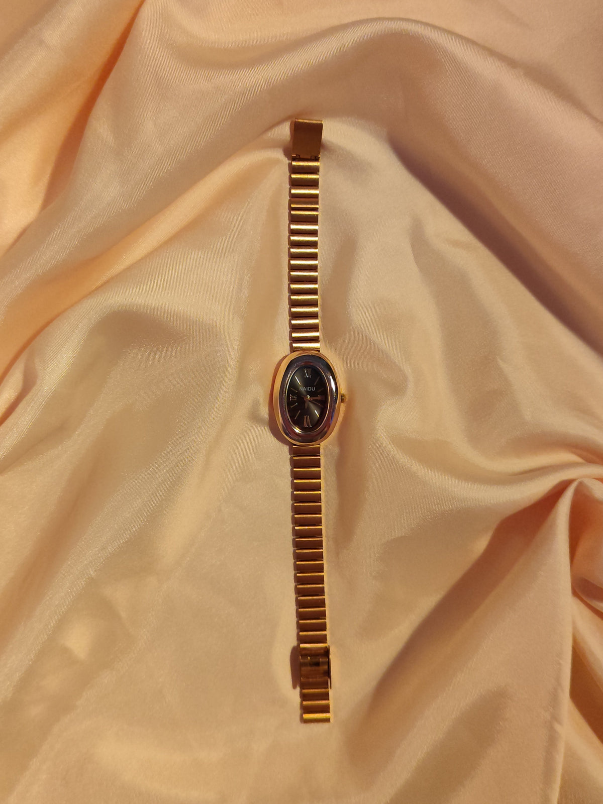 Goldene Oval-Armbanduhr mit schwarzem Zifferblatt