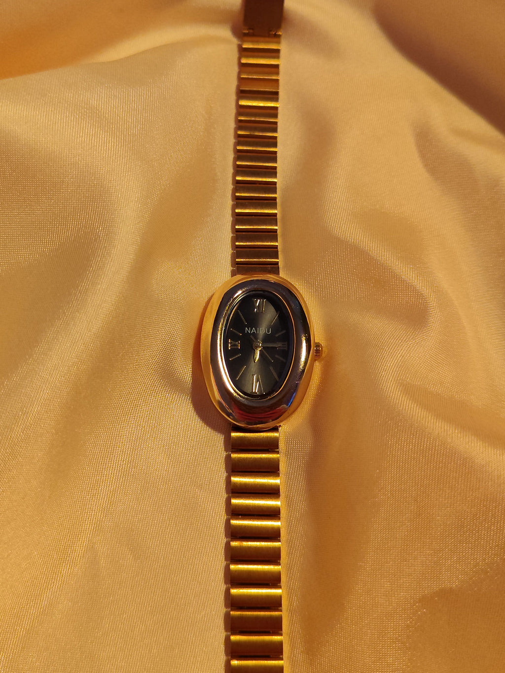 Goldene Oval-Armbanduhr mit schwarzem Zifferblatt