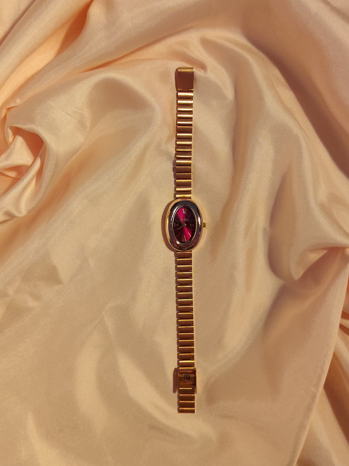 Ovale Armbanduhr in Gold & Bordeauxrot