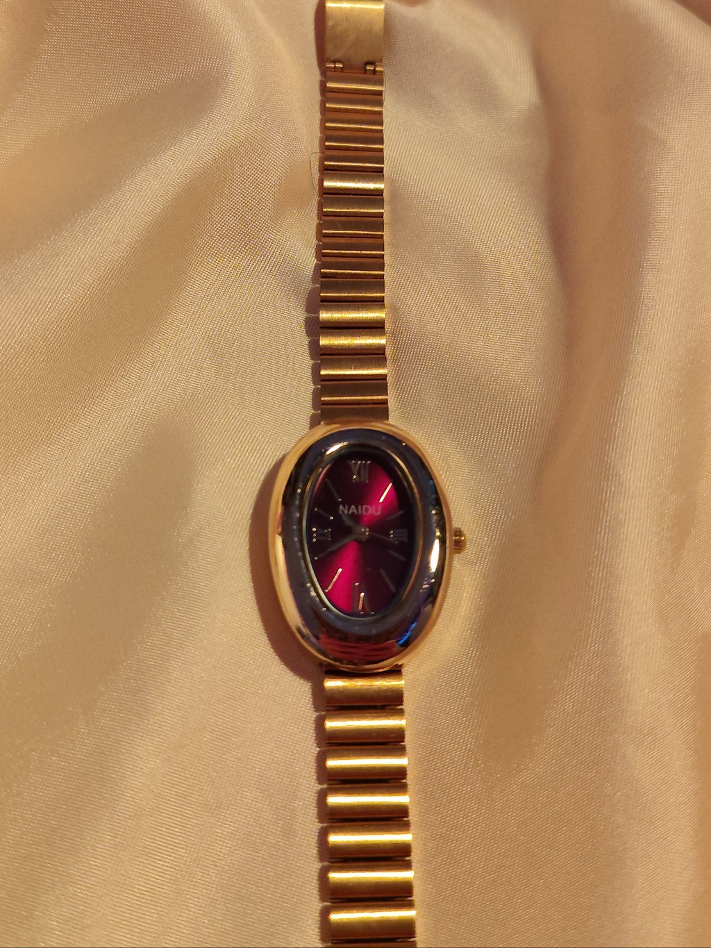 Ovale Armbanduhr in Gold & Bordeauxrot