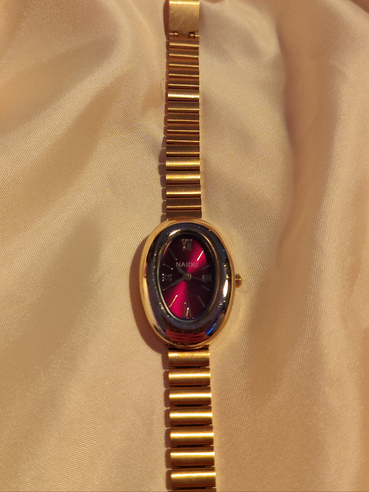 Ovale Armbanduhr in Gold & Bordeauxrot